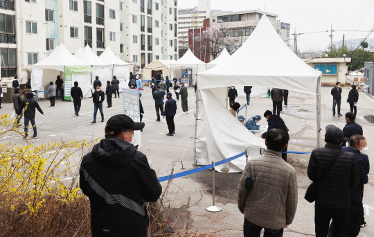 코로나19 신규 확진자가 닷새 연속 400명대를 기록한 지난 21일 오전 서울 금천구청 앞에 마련된 외국인 임시선별검사소에서 외국인들이 검체 검사를 받기 위해 줄을 서 있다. 연합뉴스